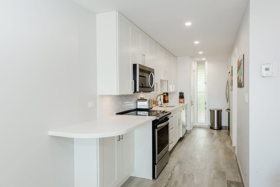 Modern kitchen, appliances, and wood grained tile flooring