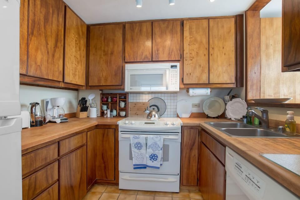 Custom Hawaiian koa cabinetry in a fully stocked kitchen.