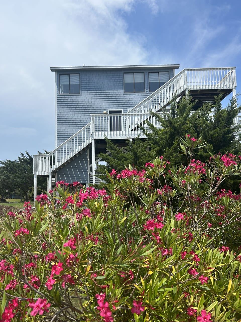 Beautiful flower lined boardwalk to beach at edge of property