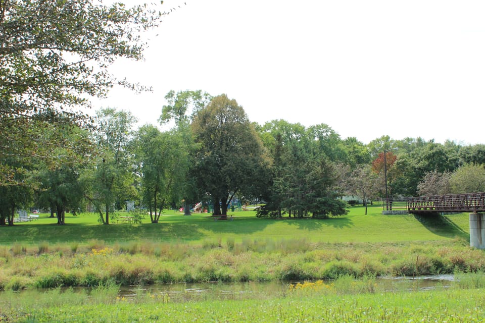 Public park across the street with trails, playground, and creek