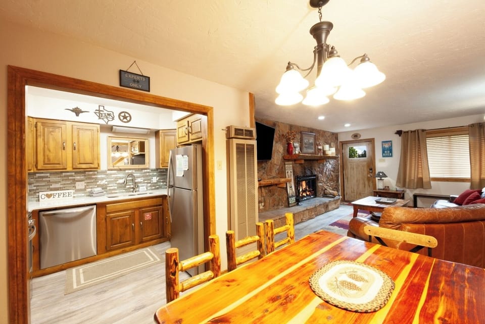 Gather around the beautiful wooden dining table, with a cozy fireplace and fully equipped kitchen just steps away—perfect for your home-away-from-home moments.