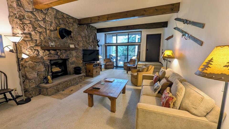Living room with sofa bed, wood fireplace, and balcony w/ propane BBQ grill