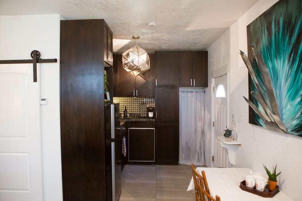 Kitchen with Keurig coffee maker, utensils, pots/pans, glasses, and more.