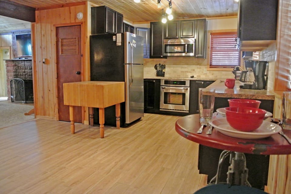 Step into your well-equipped kitchen with modern stainless appliances, warm wood finishes, and a cozy dining spot—ready for home-cooked meals and morning coffee.