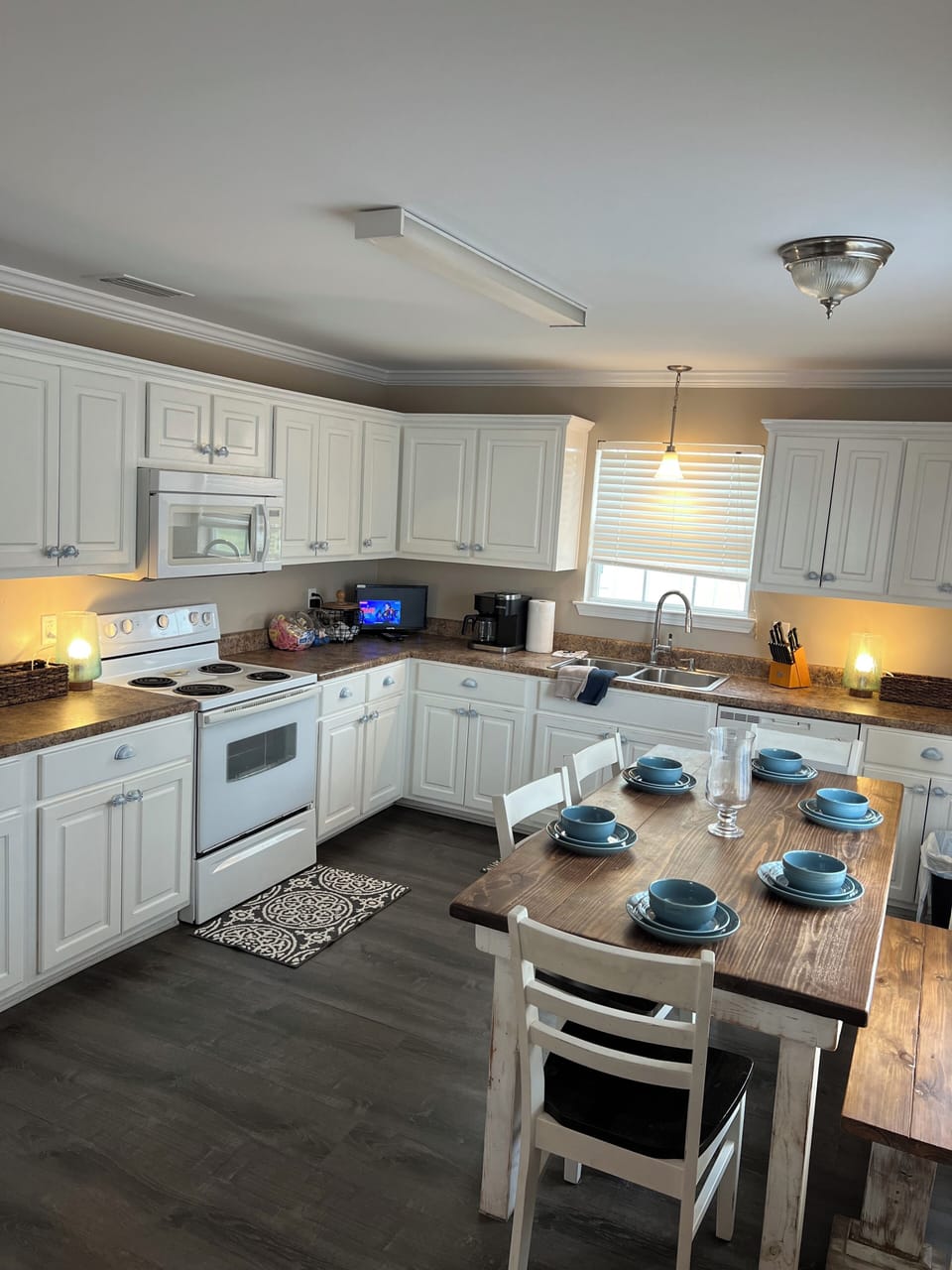 Completely furnished kitchen with plates, flatware, glassware, and pots & pans.
