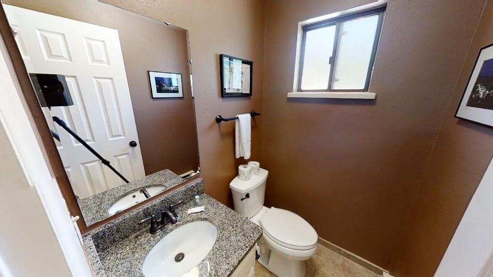 Your private bathroom features warm tones, granite countertops, and natural light—a cozy spot to refresh during your stay.