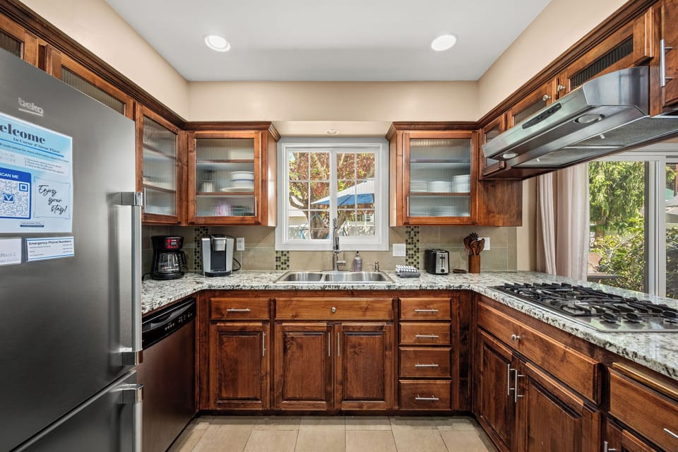 Your fully equipped kitchen features warm wood cabinetry, granite countertops, and modern appliances—perfect for preparing home-cooked meals during your stay.