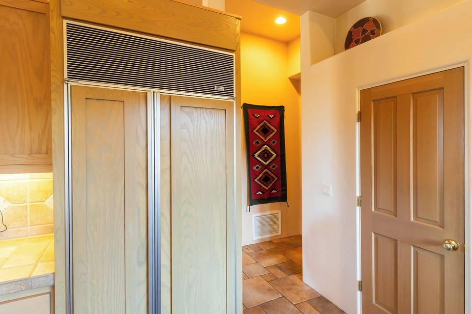 Kitchen showing Subzero refrigerator and pantry door.