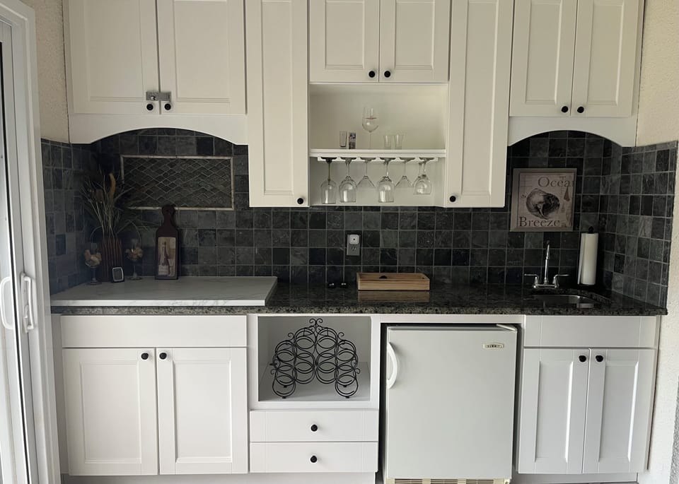 Lanai with granite countertop, refrigerator, sink