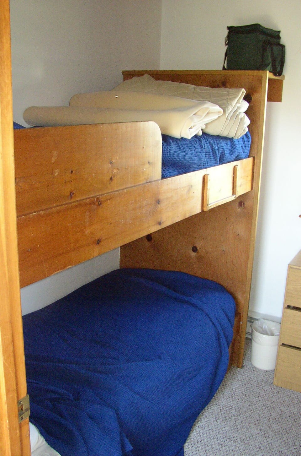 2 of 4 beds in small bunk room. Dresser, window, reading light for each bed.