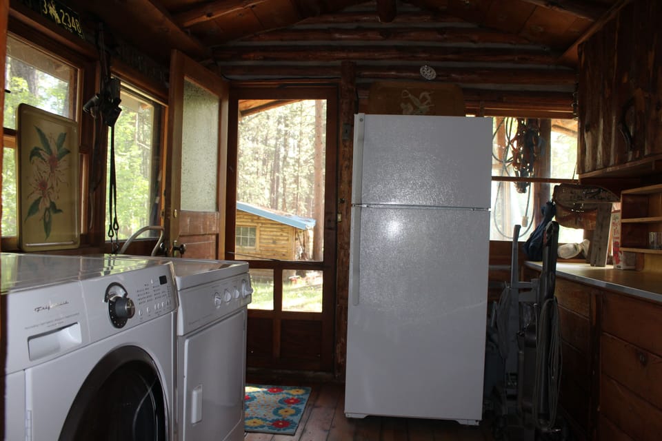 Mudroom with laundry and refrigerator.