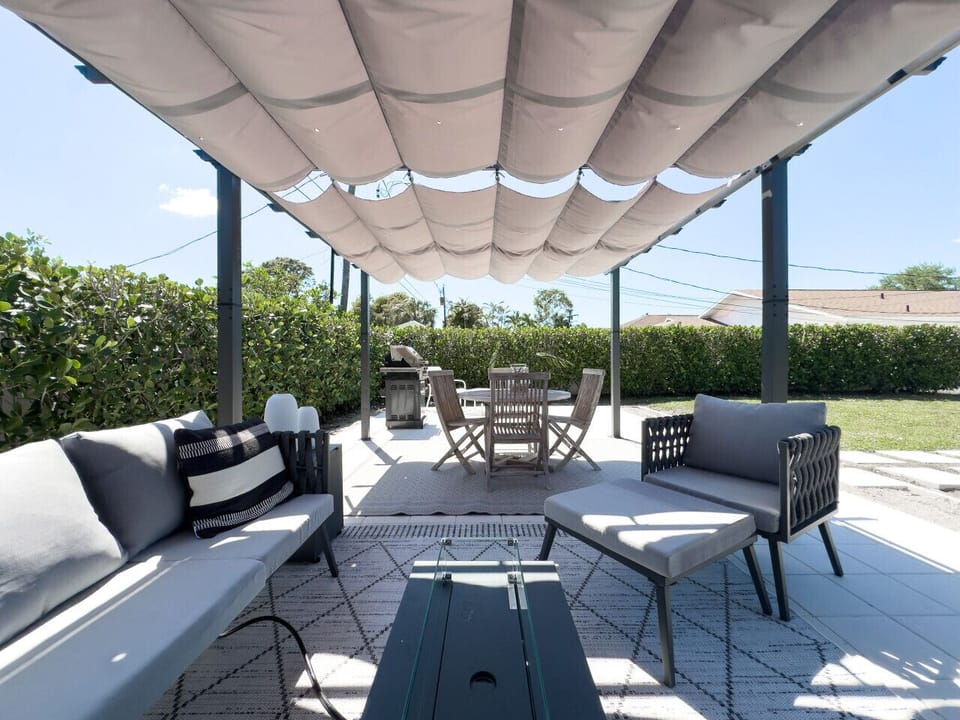 Modern Pergola Covered Outdoor Space with Sitting Area and Gas Fire Table; Dining Area with Natural Teak Wood Dining Table and Gas BBQ Grill