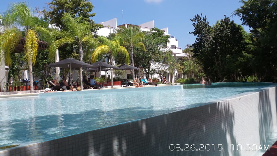Tao main pool with lots of loungers, tables and a grill. 
