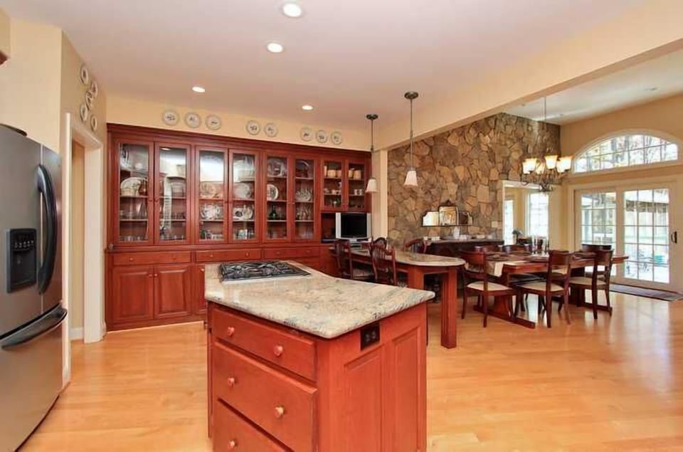 Custom gourmet kitchen with natural stone wall waterfront dining area