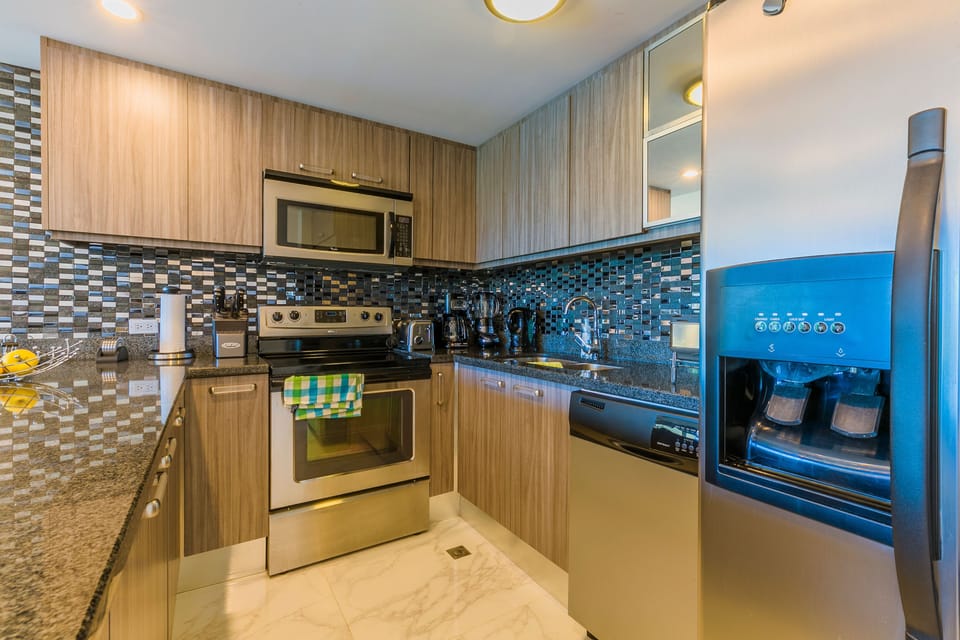 Your fully equipped kitchen features granite countertops, stainless steel appliances, and stylish tile backsplash, perfect for preparing your favorite meals during your stay.