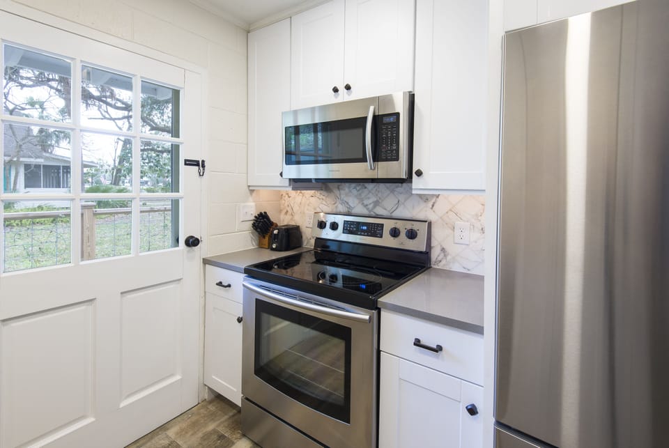 Kitchen has gorgeous quartz counter tops and stainless steel appliances.