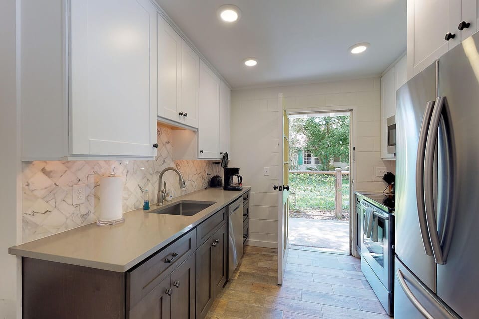 Kitchen has side door that opens to outdoor shower