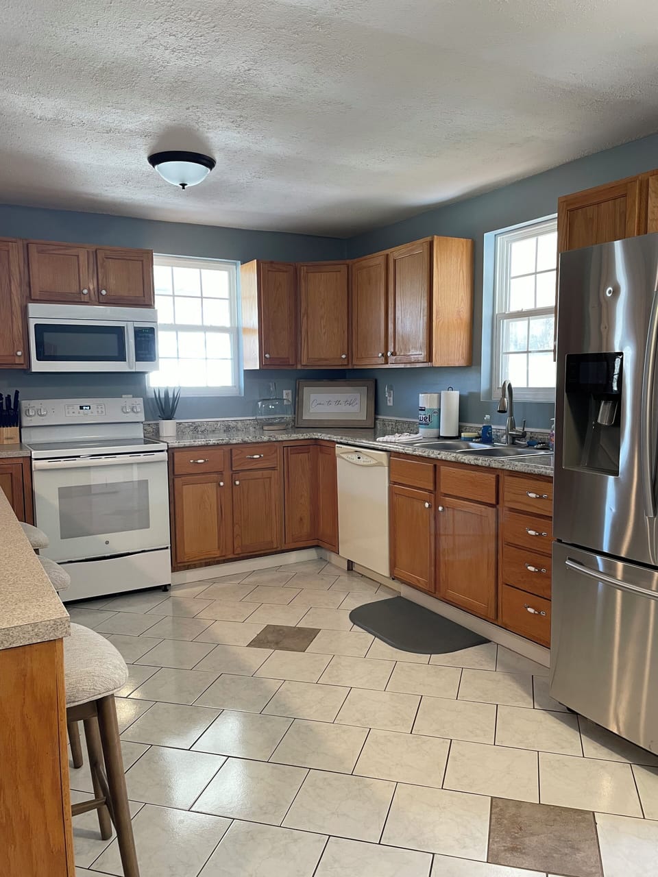 The full-sized kitchen is equipped with many appliances and necessities. 