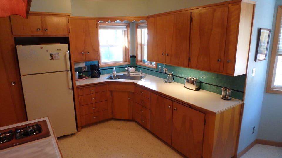 large, clean kitchen with original cabinets, and warm 
natural light.