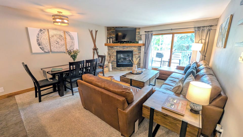 BC West J-2 living room with gas fireplace and balcony w/ propane BBQ grill