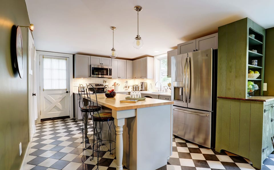 Open Plan Kitchen with Island with Vintage Stools, Refrigerator and Hutch