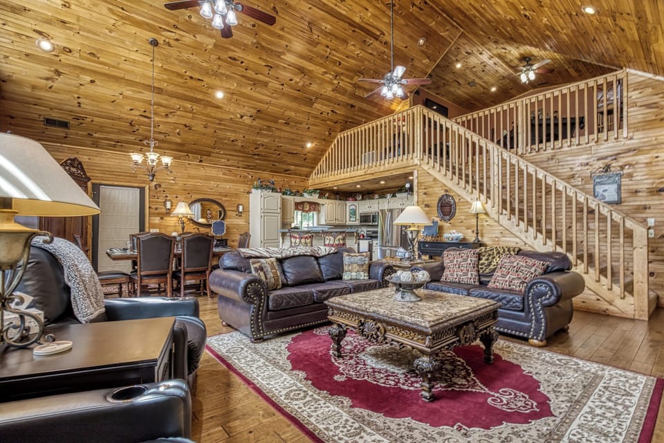 - Spacious open-concept living room with high wood ceilings   - Elegant seating area with natural light and cozy ambiance   - Perfect for family gatherings in this mountain cabin retreat