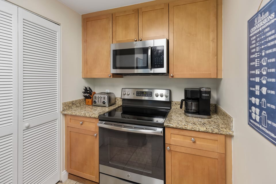 Your fully equipped kitchen features granite countertops, stainless steel appliances, and warm wood cabinets—perfect for preparing meals together.