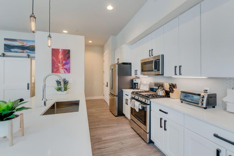 The Kitchen with  Breakfast Bar, Sink, Refrigerator, and Microwave.