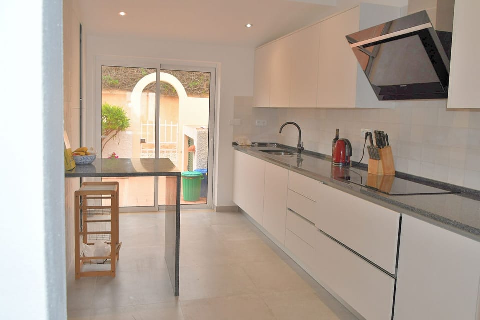 Super new kitchen with breakfast bar and doors to the kitchen patio