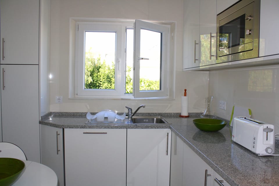 The kitchen has a pantry to the left with fridge freezer and storage space