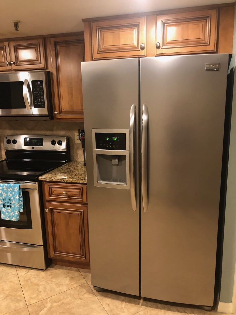 Kitchen with family size fridge/ ice maker.