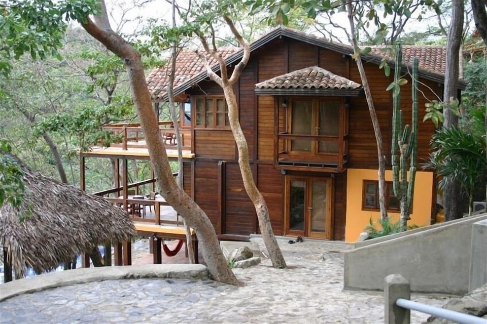 Exterior of home with the bay and palapa on the left and the casita to the right