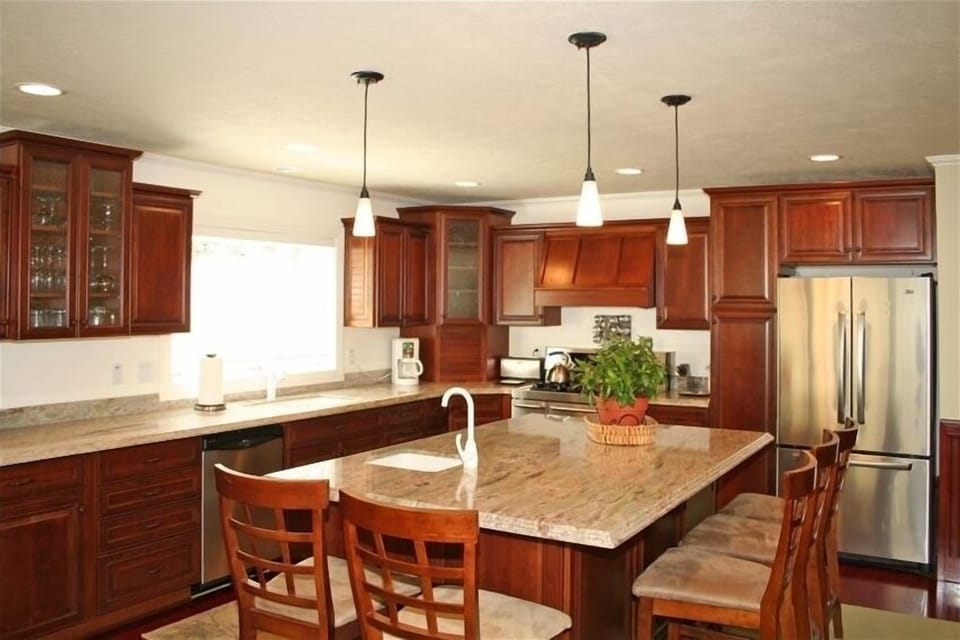 Kitchen Island with dual sinks, granite, dual range stove and cherry woodwork.