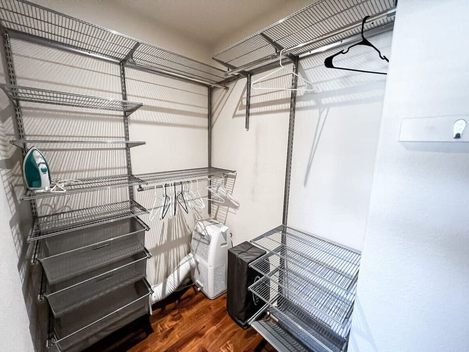 Bedroom 2 features a spacious walk-in closet equipped with ample shelving, hanging space, and an ironing station, providing convenience and organization for your stay
