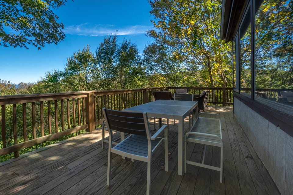 The deck includes comfortable outdoor seating and a dining table. 