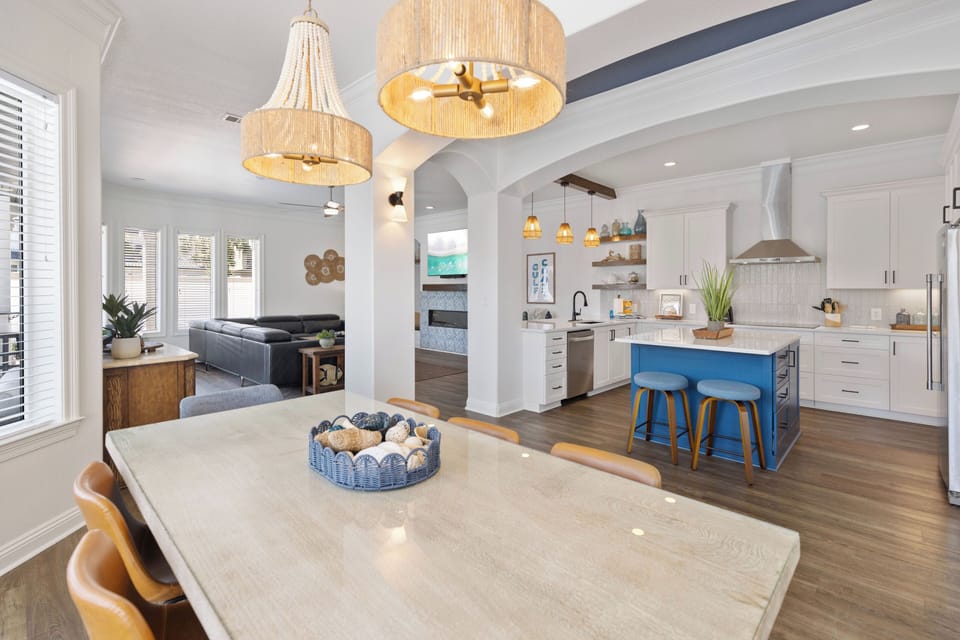 Step into your open-concept haven where warm pendant lights illuminate the spacious dining and kitchen area, perfect for memorable meals together.