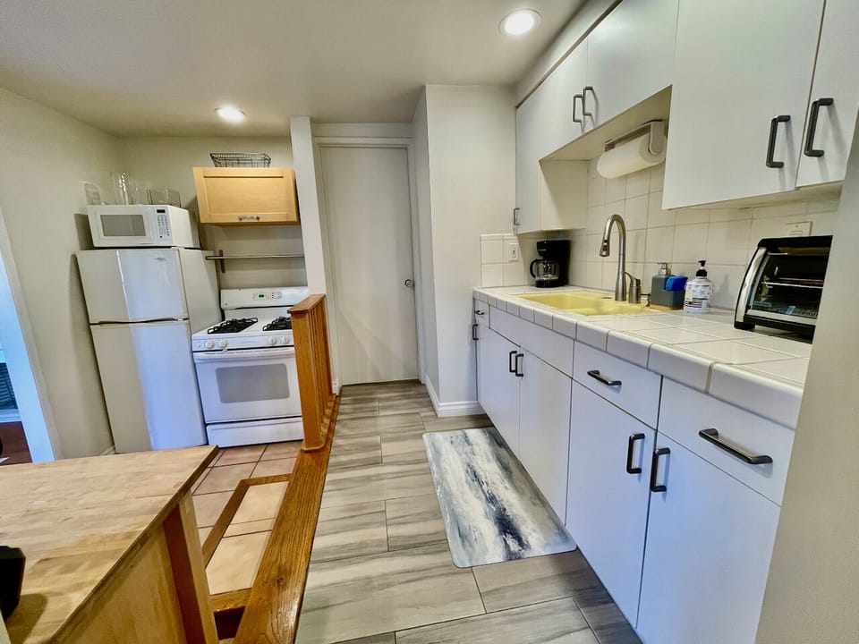 The kitchen includes most full size appliances (refrigerator, stove, microwave, toaster oven). No dishwasher. The cabinets are fully stocked.