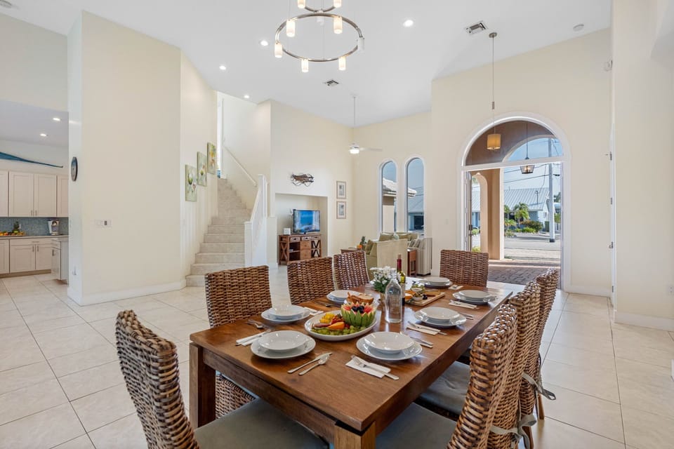 A solid wood dining table with woven high-back chairs comfortably seats eight.