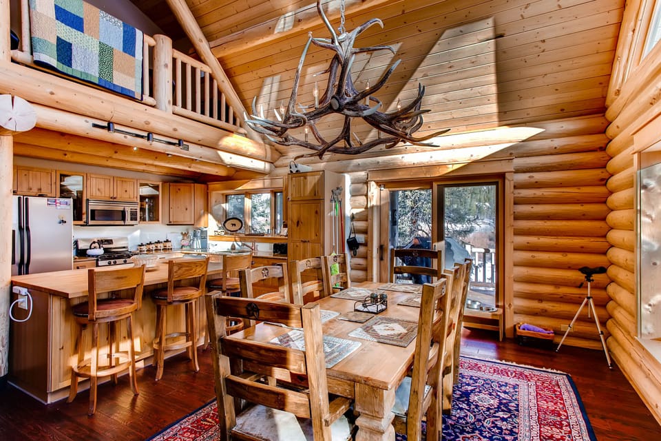 The dining room is surrounded by windows and there is access to the deck where the BBQ grill is located.