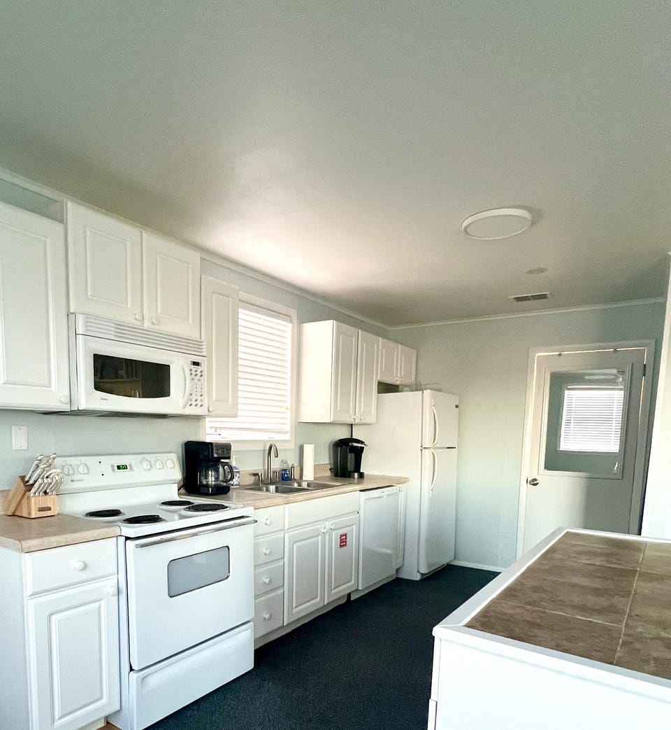 Kitchen with range, microwave, dishwasher and full size fridge