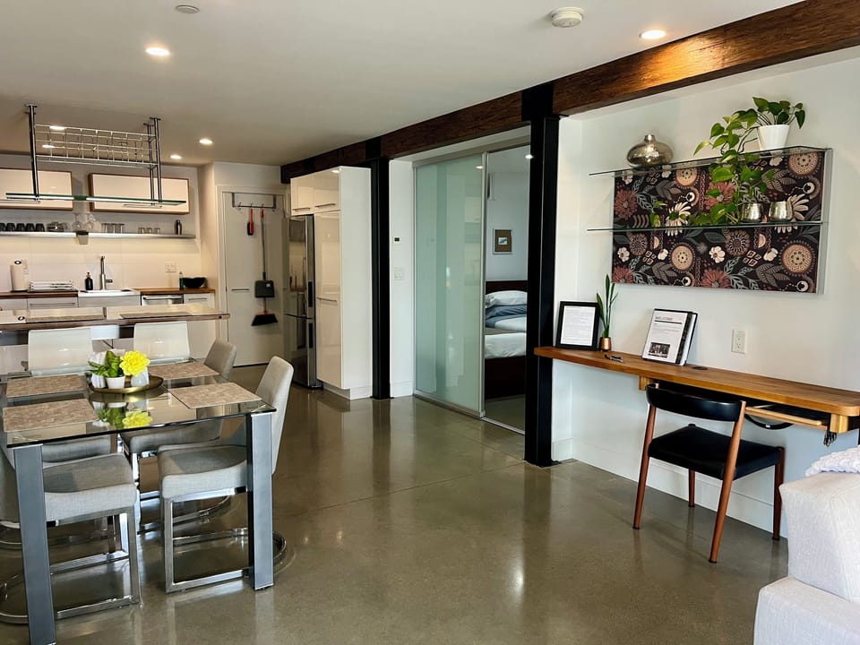From front door toward kitchen, small bedroom behind glass door.