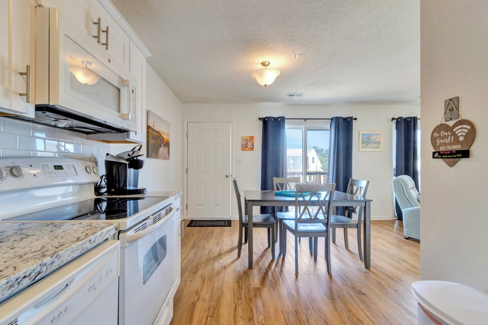Open kitchen and dining area with table for 4 and views out from the balcony.