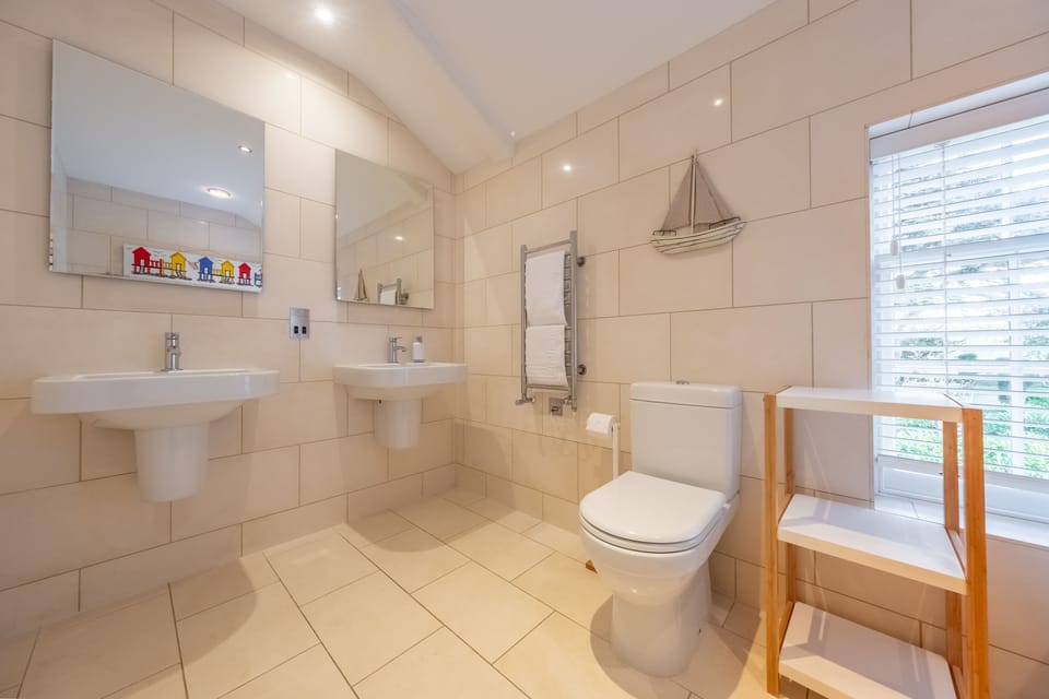 First floor: Family bathroom with twin wash basins, a bath, separate shower and WC