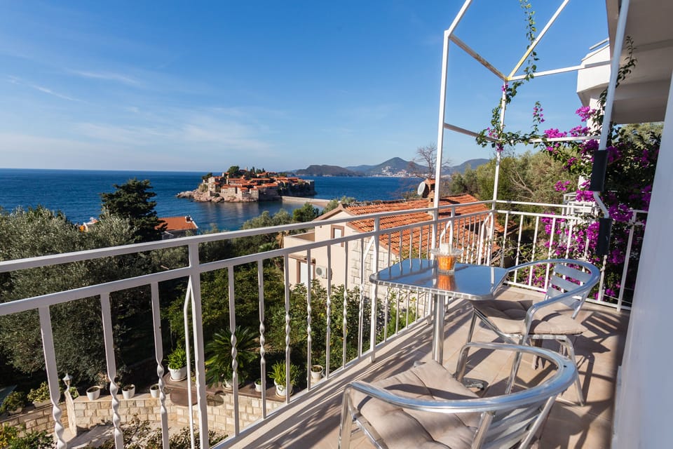 Chairs and table on private balcony with sea view.
