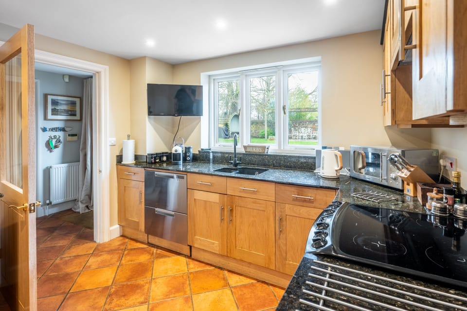 Ground floor: Kitchen and utility room, lobby and cloakroom beyond, with access to the garden