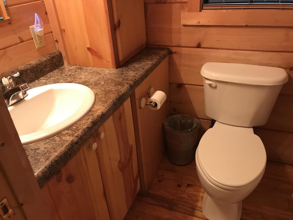 Cozy rustic bathroom with warm wood accents and granite countertop
