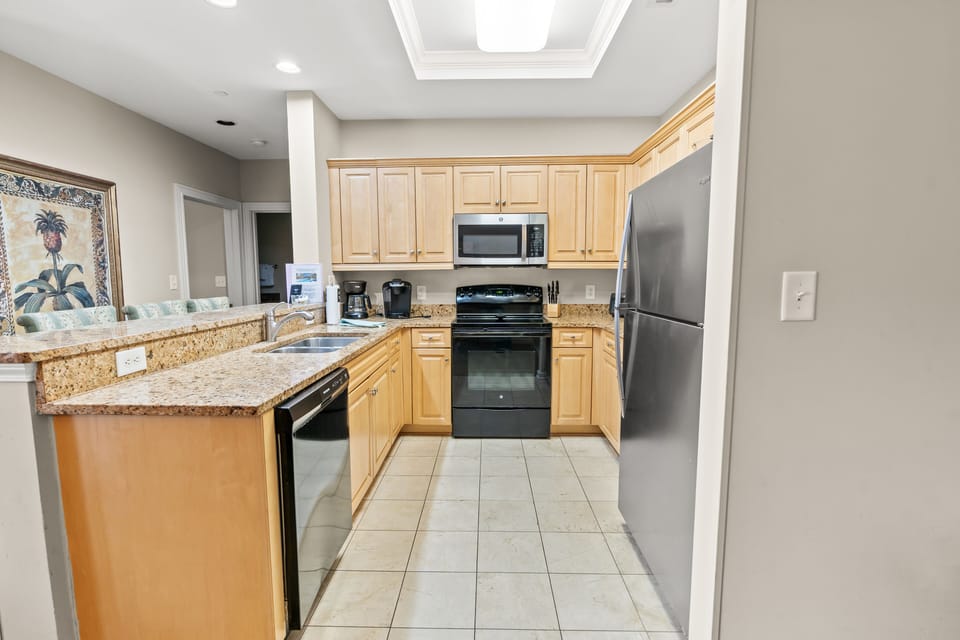 Full kitchen with dishwasher, fridge, microwave, and range. 