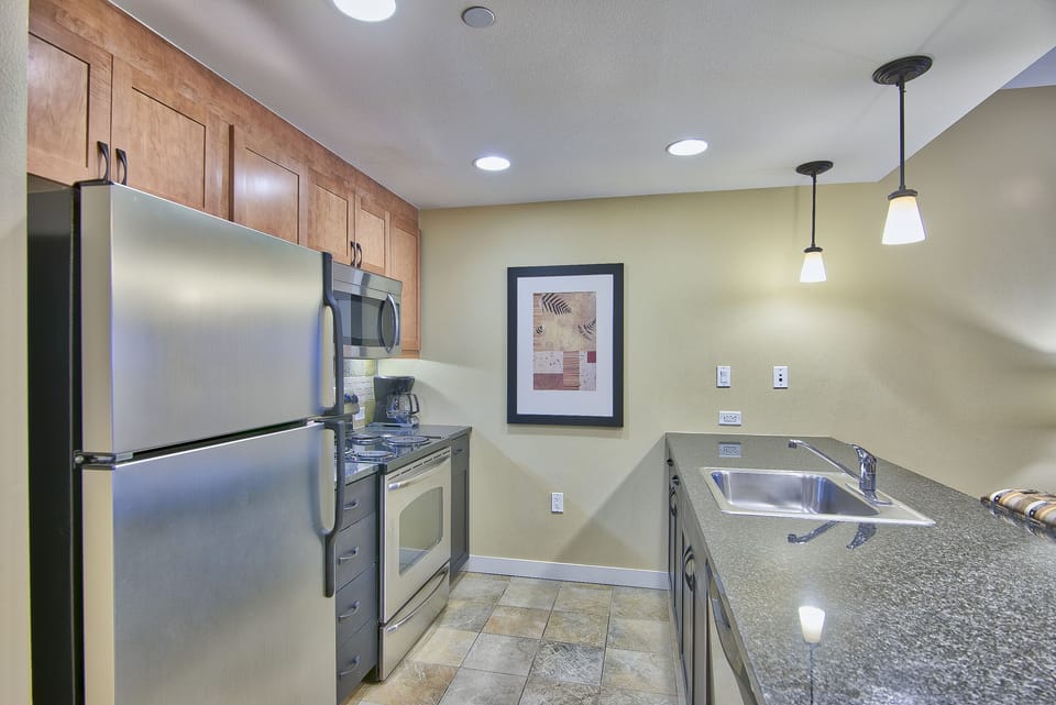 Kitchen - Granite counters, full size stainless steel appliances, and pendant lighting.