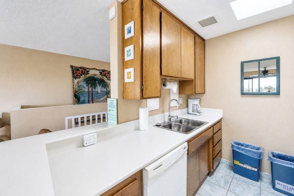 Your kitchen comes fully equipped for easy meal prep, with bright skylights overhead and ocean views framed beyond your living area, ready to make your stay feel effortless.