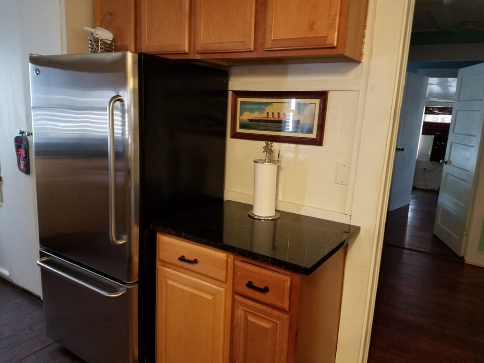 Large stainless refrigerator with icemaker, granite tops,  wood cabinettes